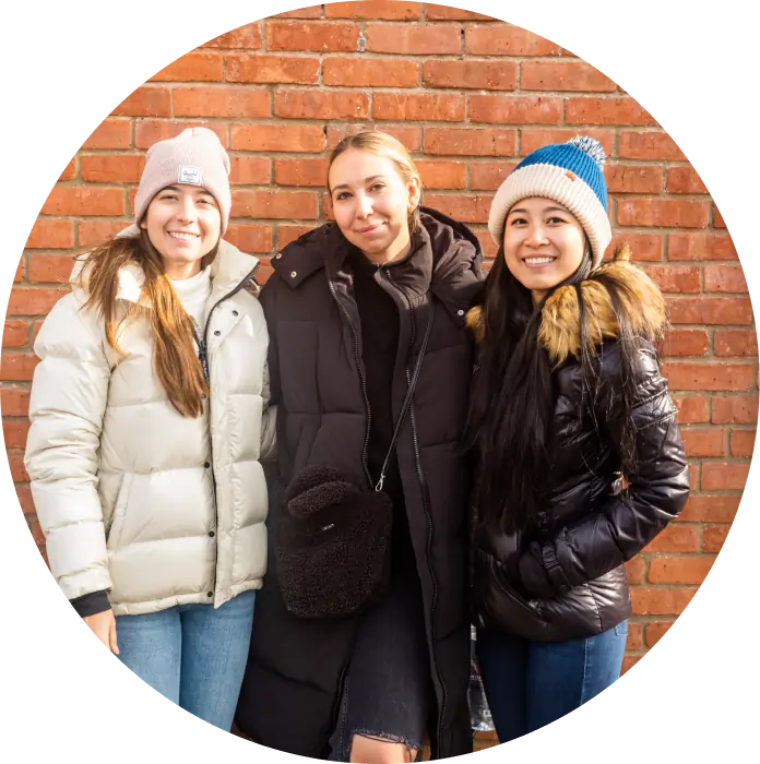 3 people in front of brick wall